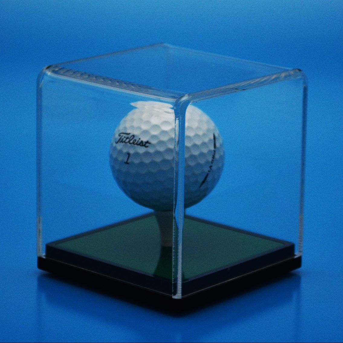 Clear Acrylic Display Cube with Black and Green Base and golf ball