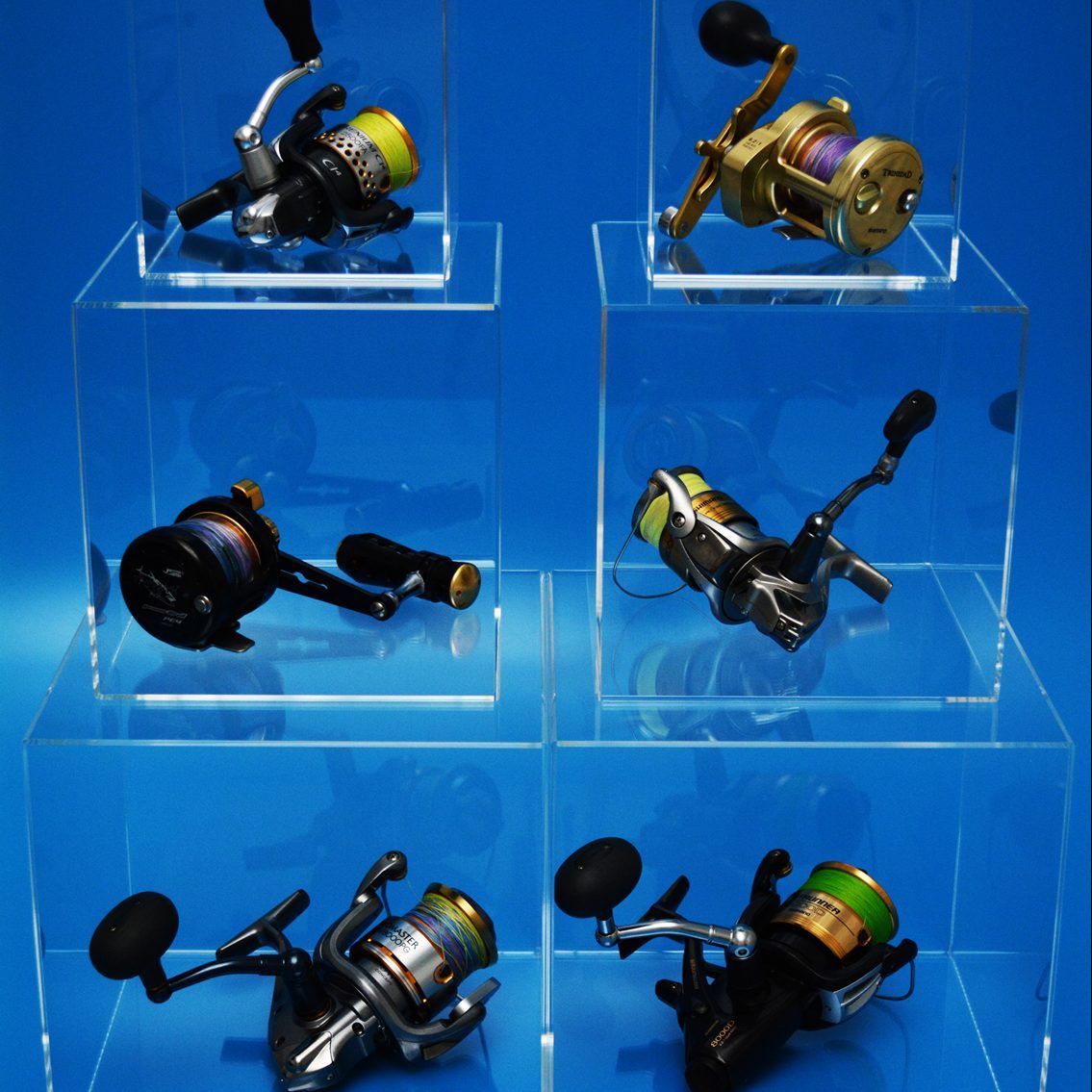 Clear Acrylic display cubes holding fishing reels, stacked on top of each other