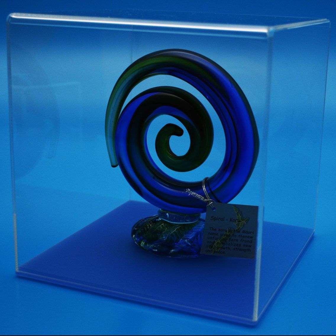 Clear Acrylic Display Cube with Blue Base displaying a glass art piece