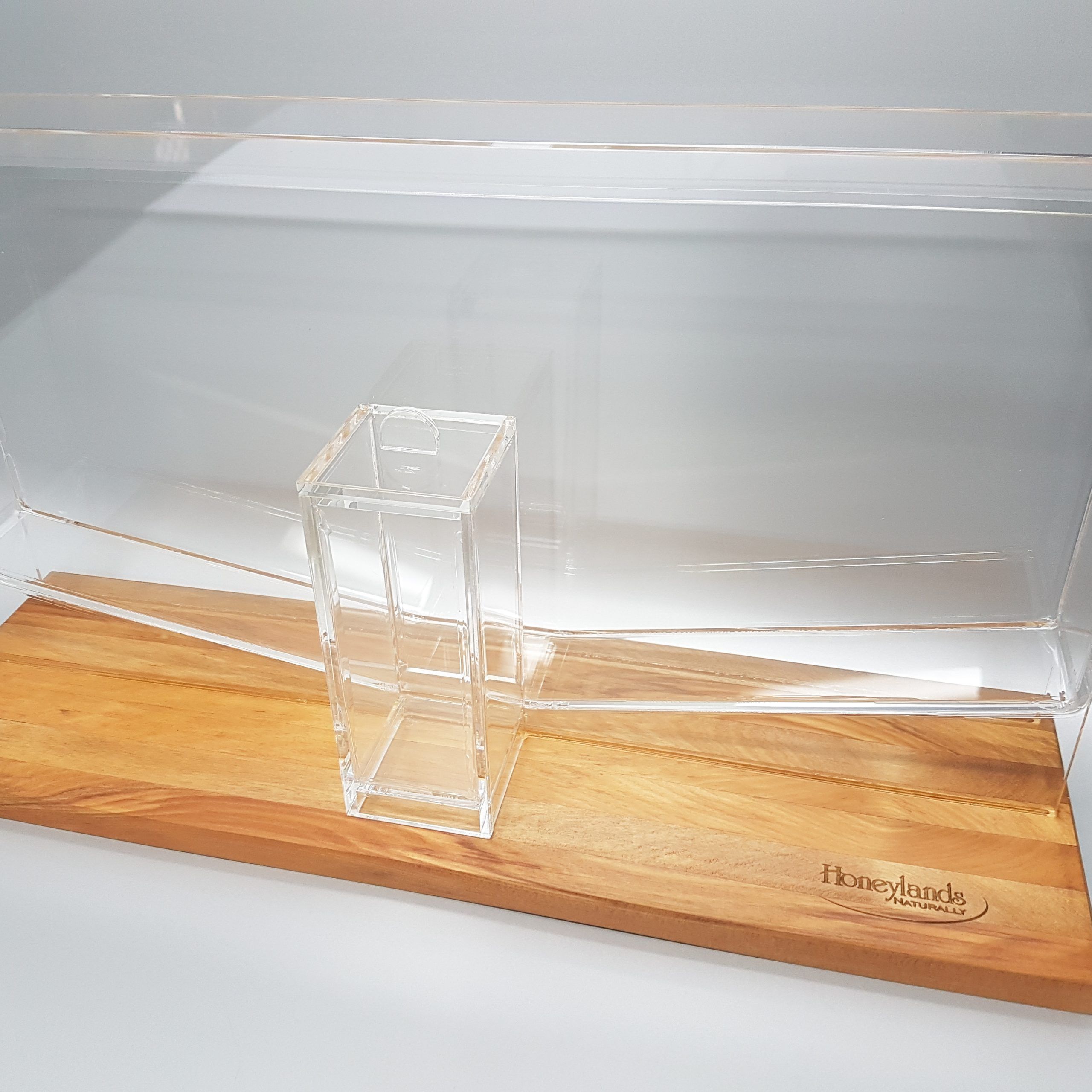 Custom clear acrylic honey dripper glued to engraved wooden base