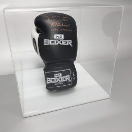 Clear acrylic disply cube with white base, housing a signed boxing glove