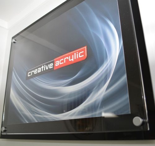 Custom made acrylic poster trap using a clear acrylic panel and a black acrylic panel and satin sign mounts attached to the wall
