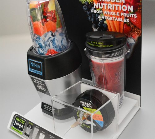 Acrylic shelf top display holding product, with a separate boxed section and pvc backing panel