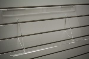 Clear acrylic slatwall tilt shelf, empty