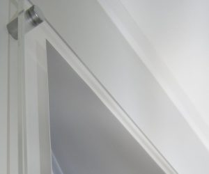 Wall mount poster trap corner with satin chrome sign mount attaching to the wall.