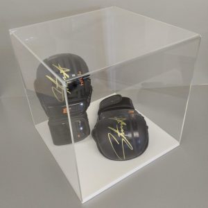 Clear acrylic 5-sided display cube on a white acrylic base, housing signed boxing gloves.