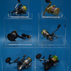 5-sided clear acrylic display cubes of various sizes, stacked on top of each other, housing fishing reels